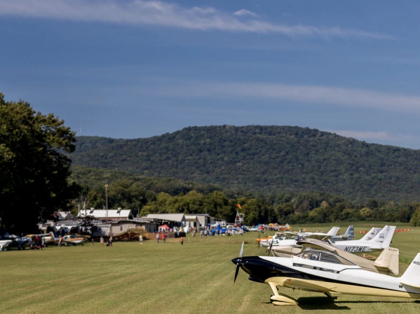 Aircraft gathered at Moontown Airport with a mountain ridge in the background.